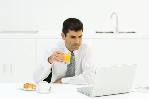 Man having breakfast and using laptop 스톡 사진