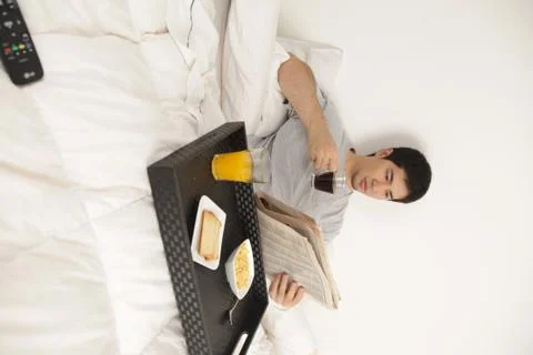 Man having a breakfast while reading the newspaper 写真素材