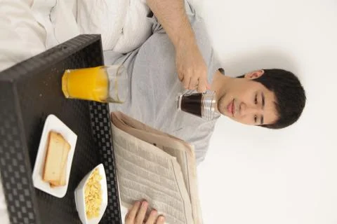 Man having a breakfast while reading the newspaper Фото
