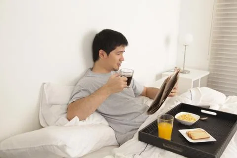 Man having a breakfast while reading the newspaper Stock Photos