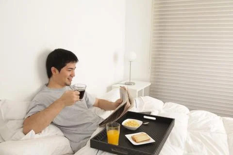 Man having a breakfast while reading the newspaper 写真素材