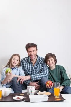 Man having a breakfast with your two childrens. Stock Photos
