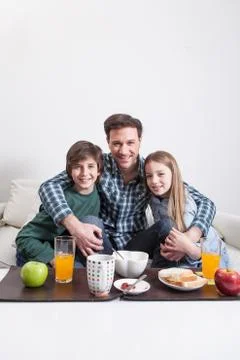 Man having a breakfast with your two childrens. Stock Photos