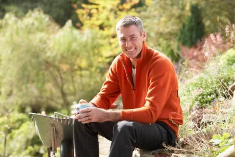 Man having coffee break whilst working outdoors in garden Stock Photos
