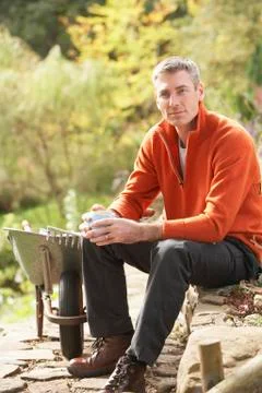 Man having coffee break whilst working outdoors in garden Stock Photos