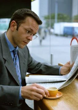 Man having coffee while reading newspaper 스톡 사진