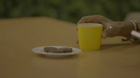 A man having coffee in a yellow cup in an office cafeteria Stock Footage 284003230