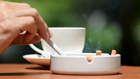 Man having conversation while smoking cigarette and drinking coffee outdoor . Stock Footage 125544039