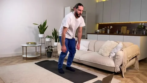 Man having daily training program, watching video tutorial at home Stock Footage 229485564