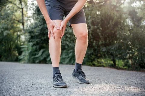 A man having difficulty in straightening or bending the knee because of bursitis Stock Photos