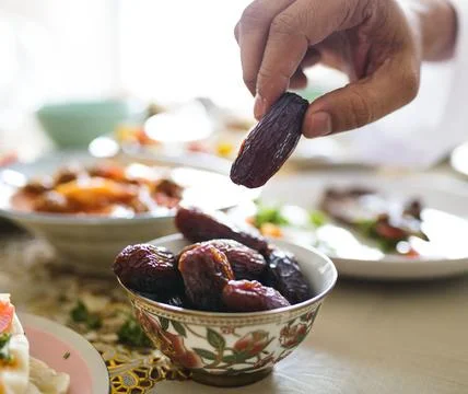 Man having a dried date at Ramadan feast Stock Photos
