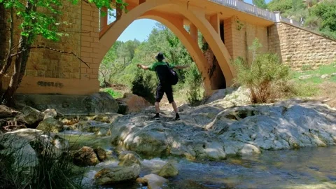 Man is having fun close to a big bridge. Dancing and jumping. Hiking in nature. Video stock 193136859