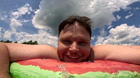 Man having fun with inflatable pool ring at the lake Stock Footage 261514552