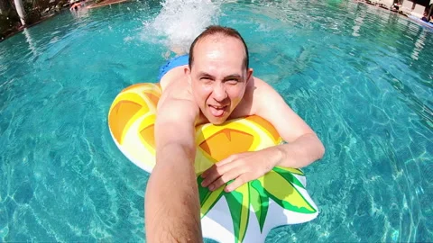 Man having fun on pool mattress in swimming pool in slow motion 250fps Video stock 113954874