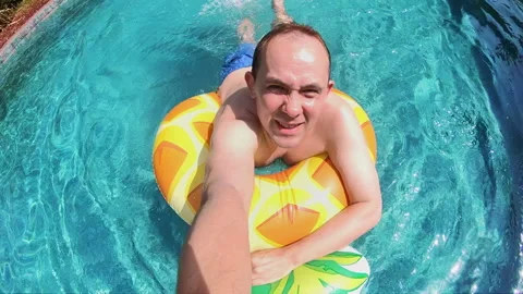 Man having fun on pool mattress in swimming pool in slow motion 250fps Video stock 113999647