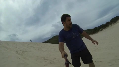 A man having fun riding a sandboard on the dunes of Florianopolis city in South  Stock Footage 149001753
