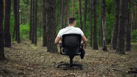 Man having fun rotates on an office chair in the forest Stock-Footage 138631454