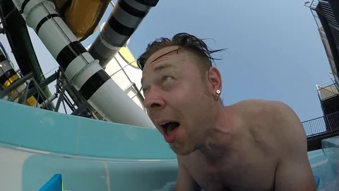 Man having fun sliding down a waterslide Video stock 107369831