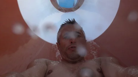 Man having fun on swimming pool slide 4K Stock Footage 117794992