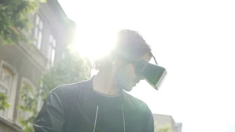 Man having fun with virtual reality glasses outdoor in the city surprised by Stock Footage