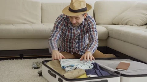 Man having fun while packing suitcase for vacations Stock Footage 130305096