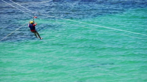 Man having fun at zipline sliding and landing in the water Stock Footage 149766043