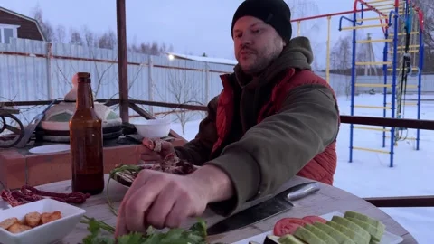 A man is having a great time eating tasty food and sipping drinks outside Stock-Footage 311925127
