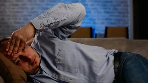 Man having headache while lying on sofa Video stock 149065387
