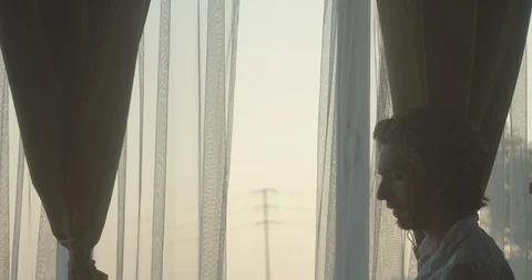 Man having an intense conversation on phone next to window in city at dusk 1 库存影片 128530653