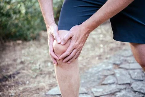 Man having knee pain while exercising, knee trauma treatment Stock Photos