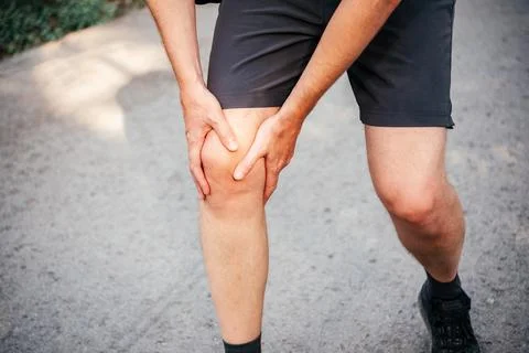 A man having knee when running or jogging Stock Photos