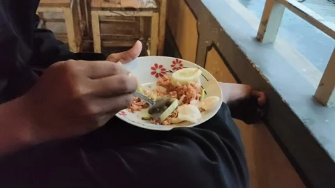 A man is having lunch at a restaurant by eating fried rice Stock Footage 227451889