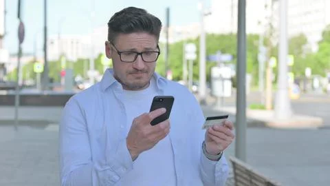 Man Having Online Payment Problem via Smartphone, Outdoor Foto stock