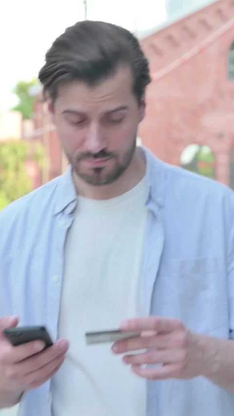 Man having Online Payment Success on Smart Phone in Street, Vertical Video Stock Footage 339664957