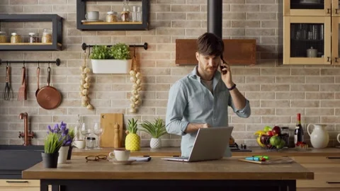 Man having phone talk in kitchen at home Stock Footage 148960965