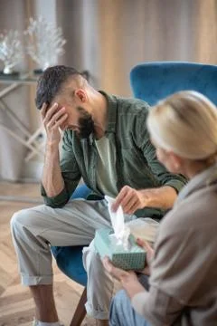 Man having some tears while sharing problems with psychoanalyst Stock Photos