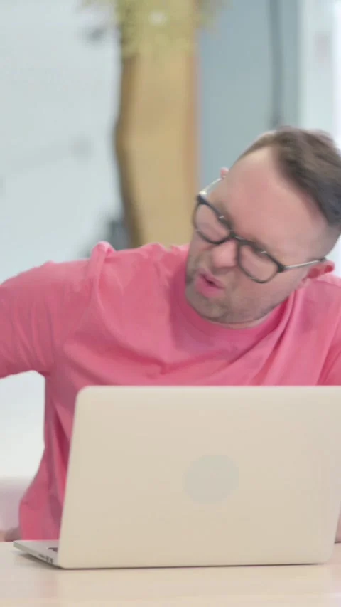 Man having Spinal Pain while using Laptop, vertical video Video stock 329105586