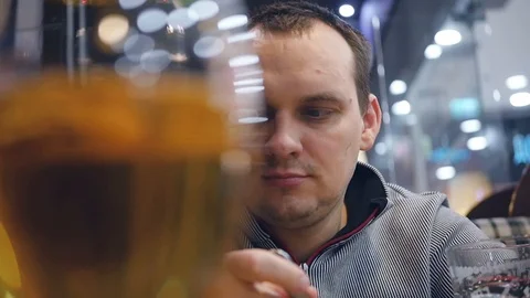 The man is having supper in the evening drinking coffee in the cafe and eating a Stock Footage 85795362