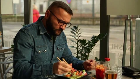 Man having toothache while eating in restaurant Stock Footage 70999835