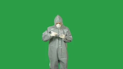 A man in a hazmat suit taking a sample with tweezers and vial. Green screen. Stock Footage 99612282