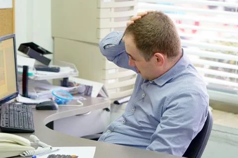 Man with a headache in front of the computer Stock Photos