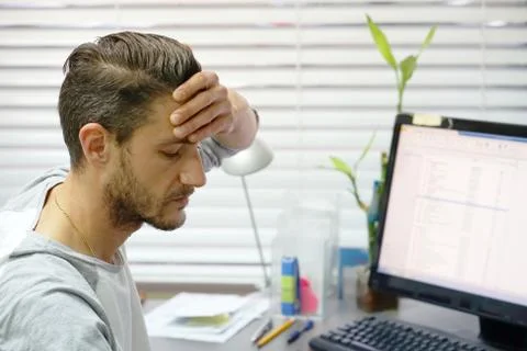 Man with a headache in front of the computer Stock Photos