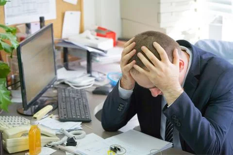 Man with a headache in front of the computer Stock Photos