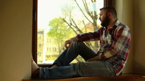 Man with headache sitting on window Stock Footage 62824489