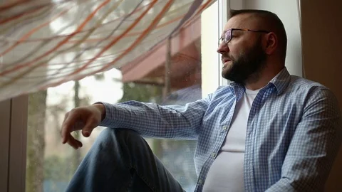 Man with headache sitting on window Stock Footage 71657858