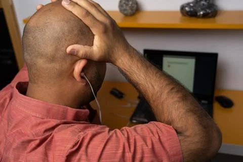 Man with headache using laptop at home Stock Photos