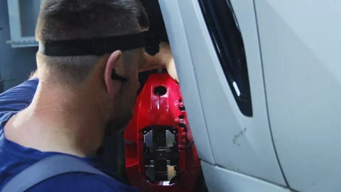 Man with headlamp assesses extent of damage to part Stock Footage 317632575