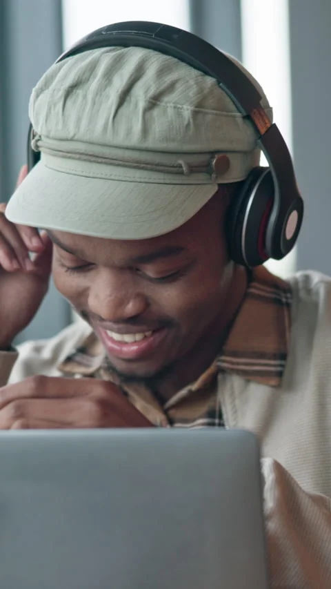 Man, headphones and remote work in coffee shop with laptop, music and smile for Stock Footage 336717342