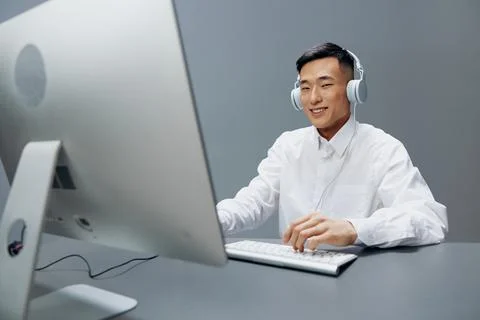 Man in headphones at the table in front of the computer isolated background Foto stock