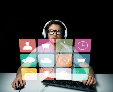 Man in headset with computer and icons on screen Stock Photos